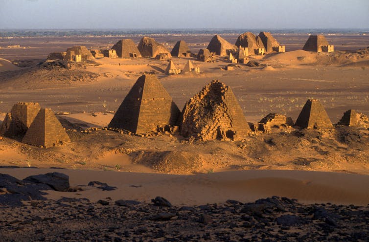 A vast landscape showing many triangular structures, smaller ones complete, larger ones breaking at the top.