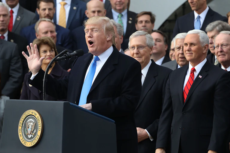 Donald Trump speaks at a lectern flanked by members of Congress early in his presidency.