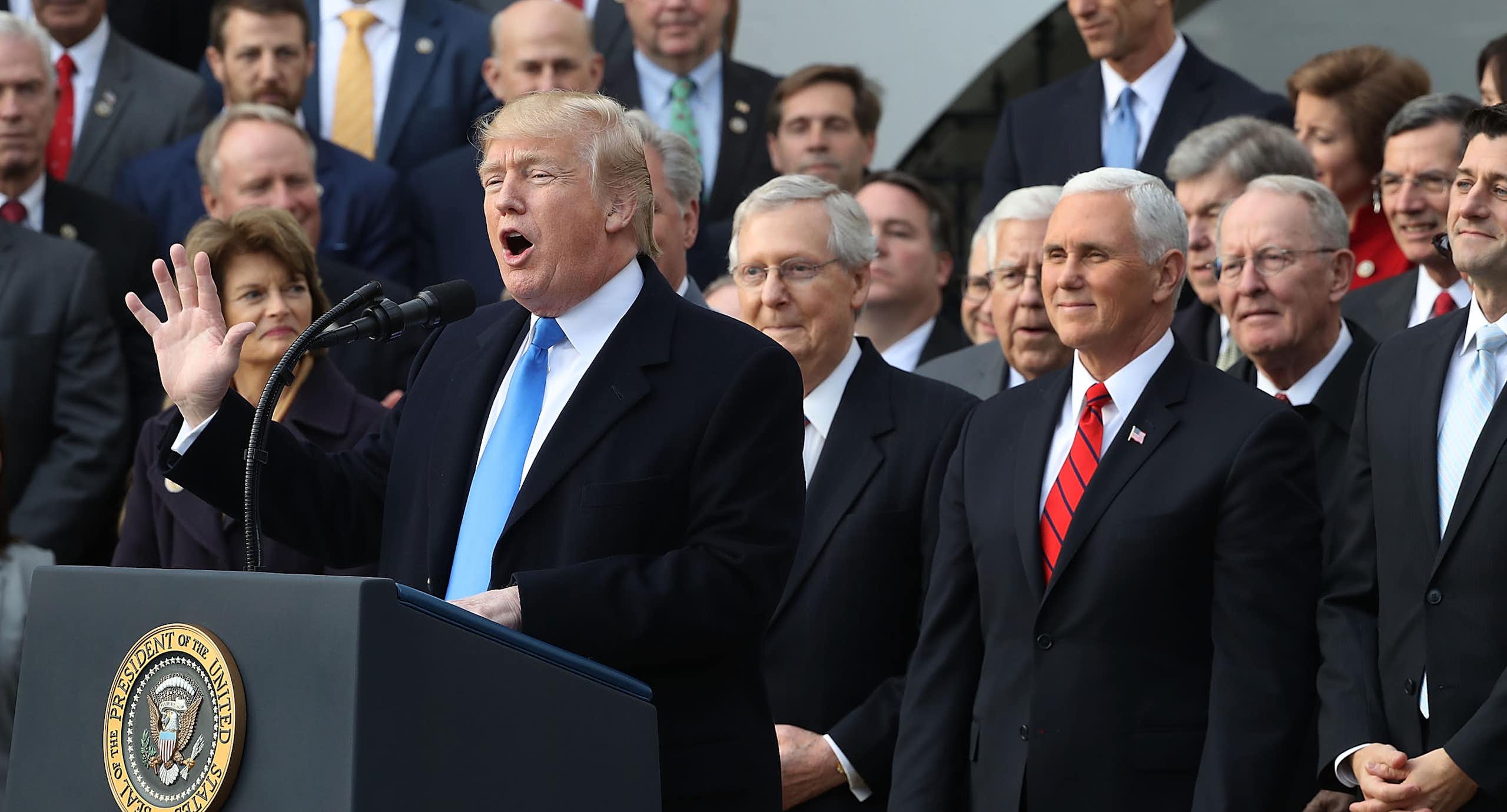 Donald Trump speaks at a lectern flanked by members of Congress early in his presidency.
