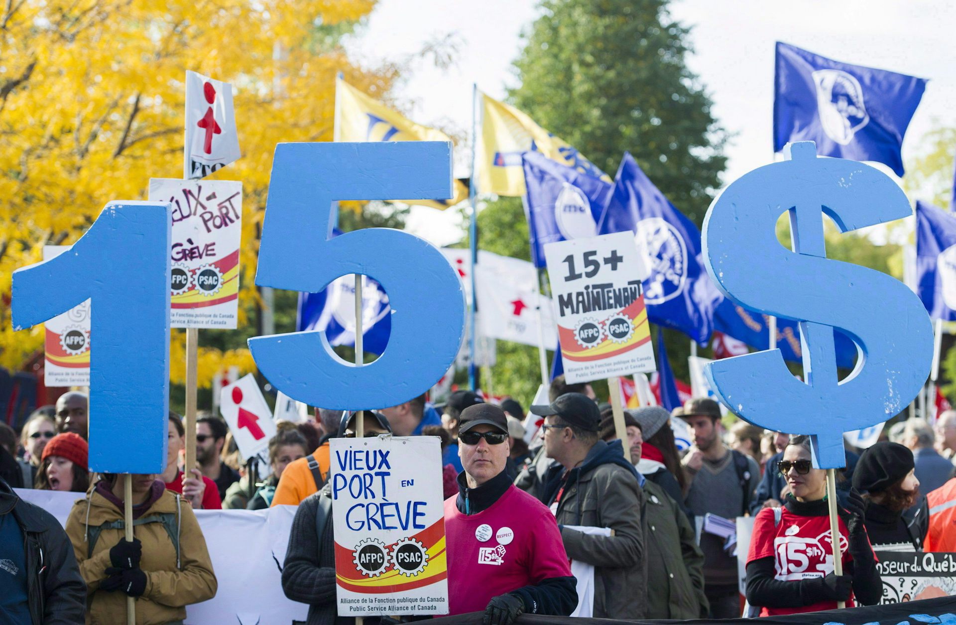 People holding protest signs calling for a $15 minimum wage