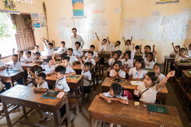 Large group of young children sitting in a classroom