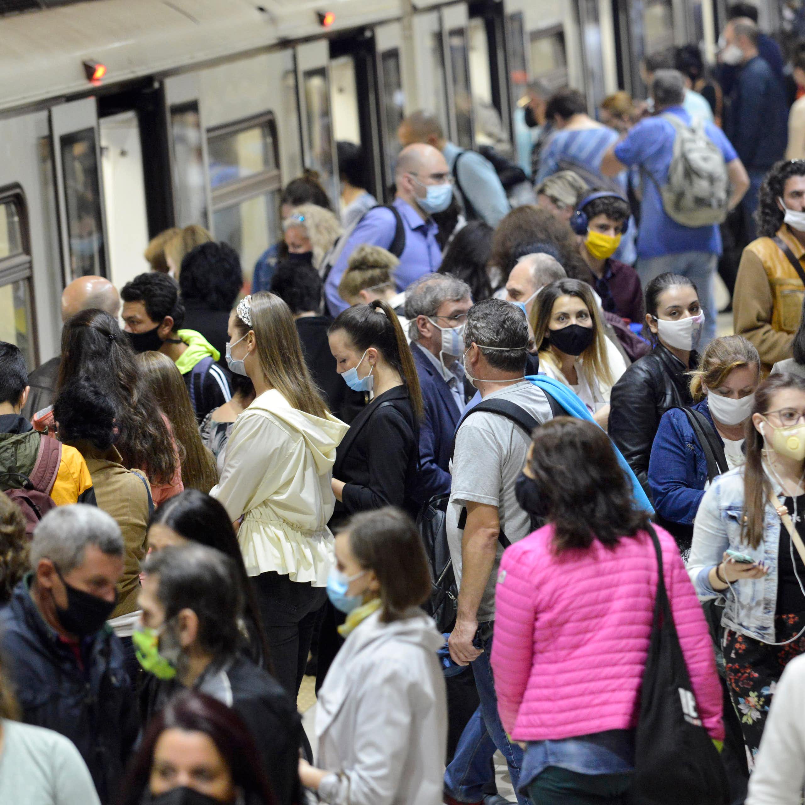 Foule de gens masqués sur un quai de gare à Sofia, en Bulgarie.
