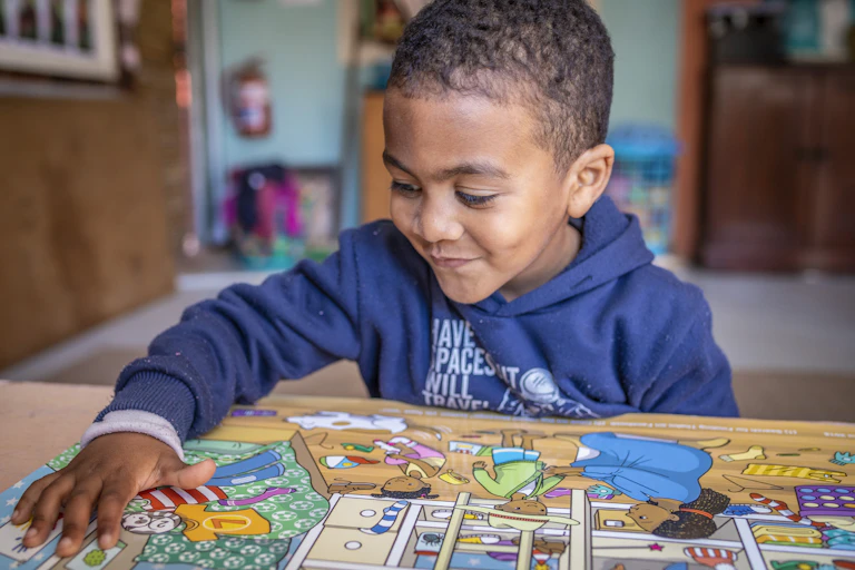 Boy looking at images laid out on a table
