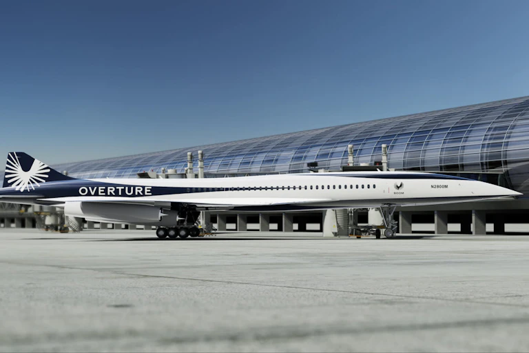 Un avión con morro afilado junto a un aeropuerto.