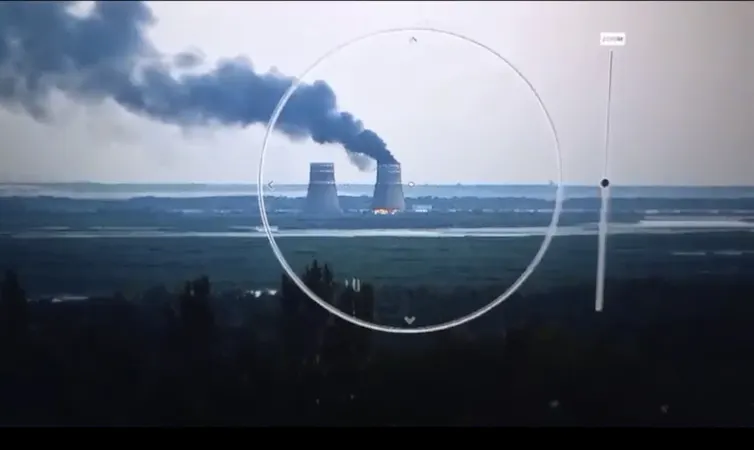 Camera view of a nuclear power plant. Smoke rises from a cooling tower