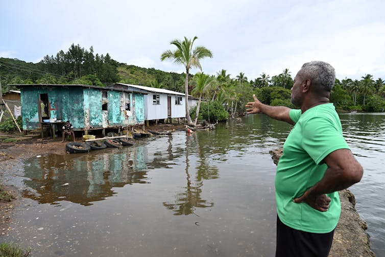 man pointing at house affected sea level rise