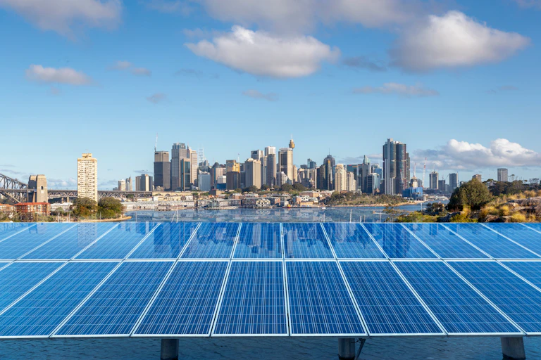solar panels in foreground, city behind