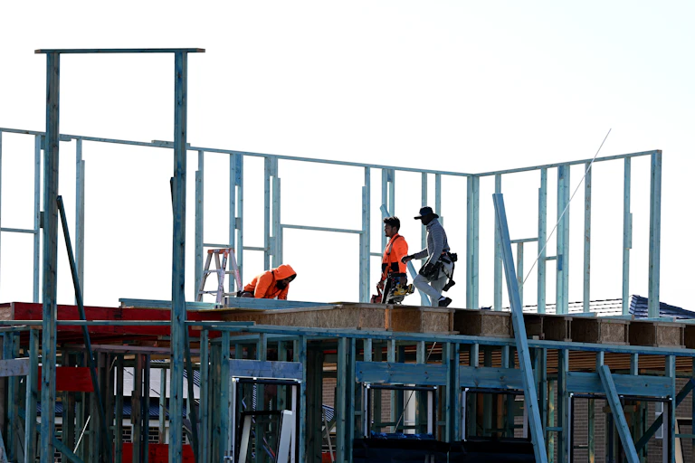 A housing construction site with workers erecting the frame