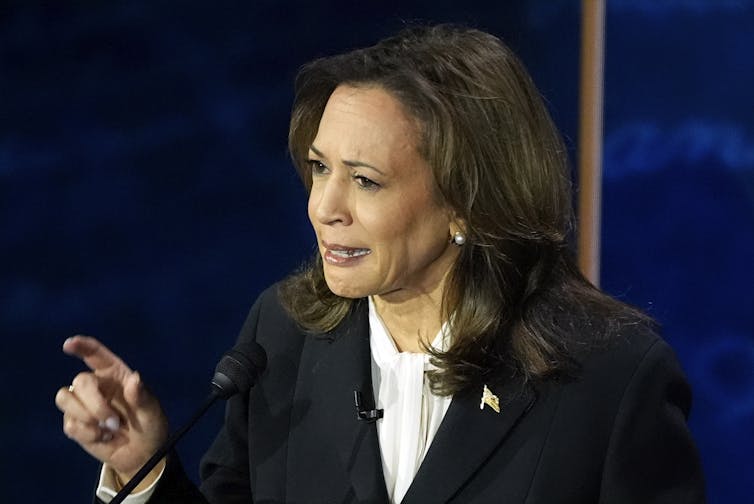 A woman makes a hand gesture.