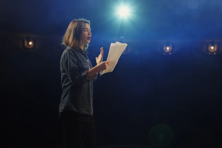 A woman reads a script.