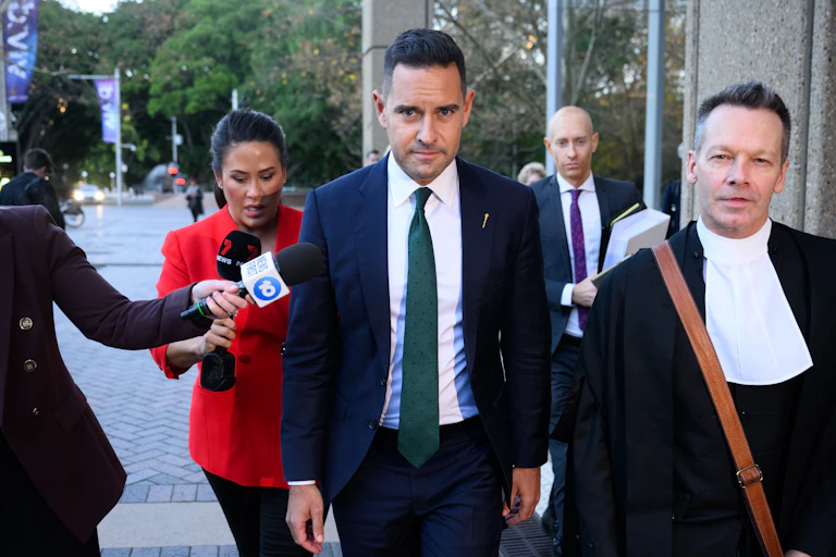 Man in blue suit walks outside court building