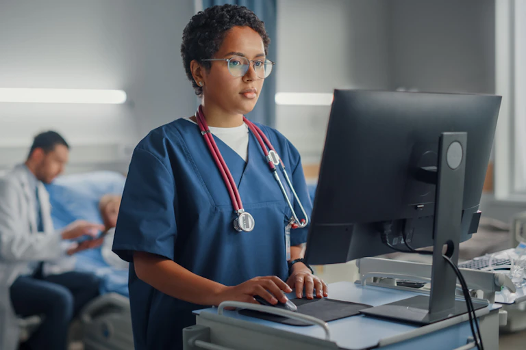 Health worker standing up at computer screen