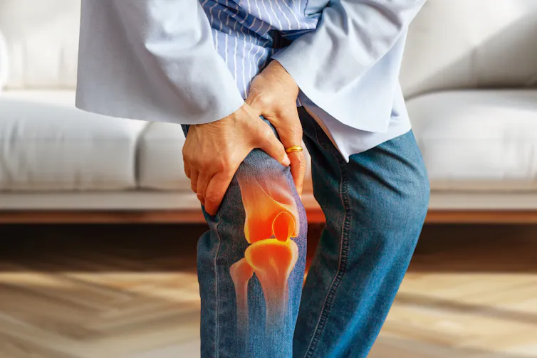 Woman bent over holding her knee, knee joint highlighted