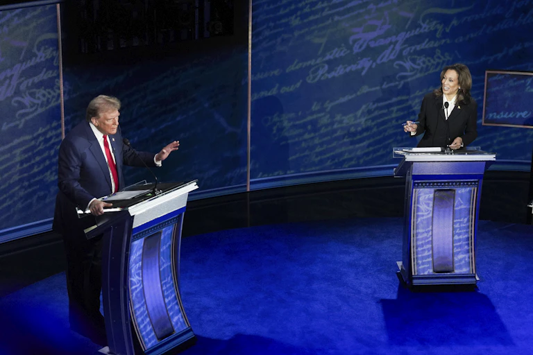 Donald Trump and Kamala Harris stand at podiums during a TV debate.