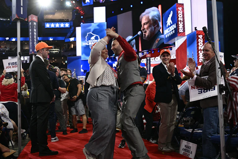 A couple dances on a red carpet.