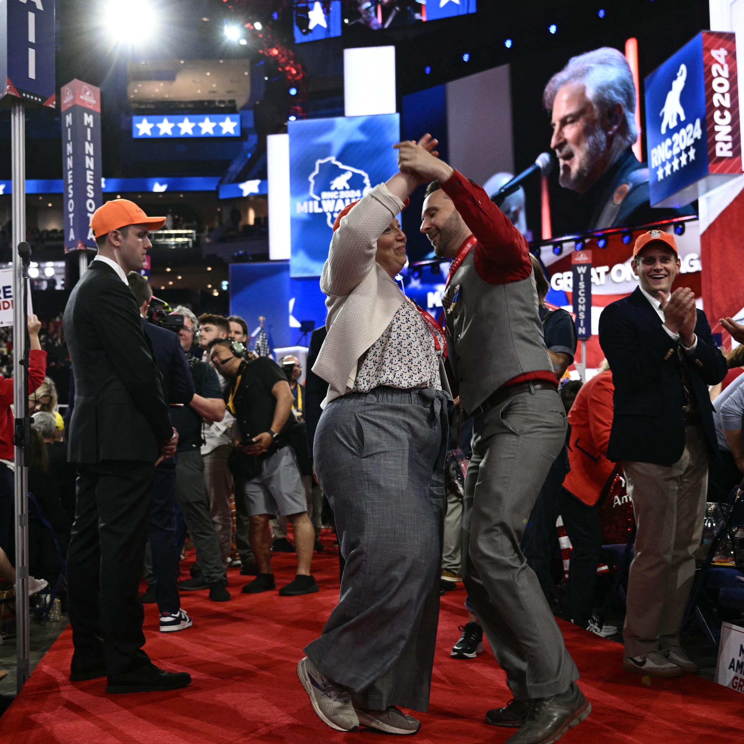 A couple dances on a red carpet.