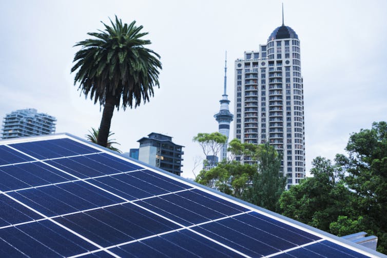 Close up of solar panels with the city of Auckland