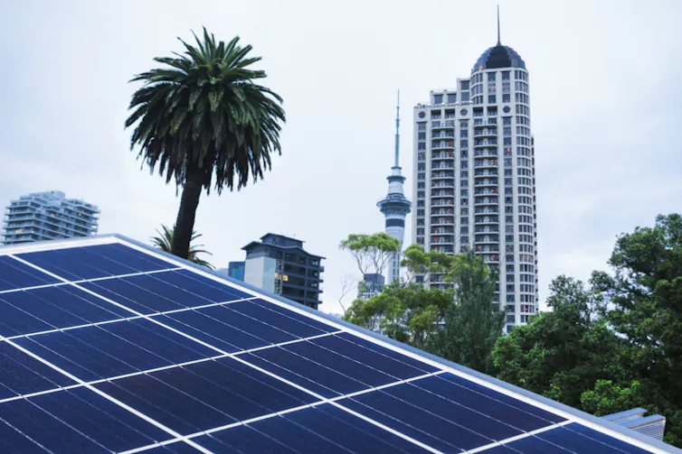 Close up of solar panels with the city of Auckland