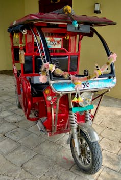 A red trishaw that has been converted to electric power