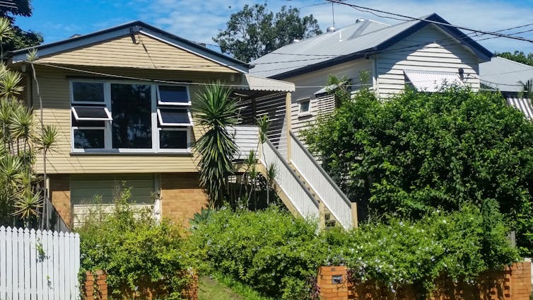 A two-storey house with its four front windows open.