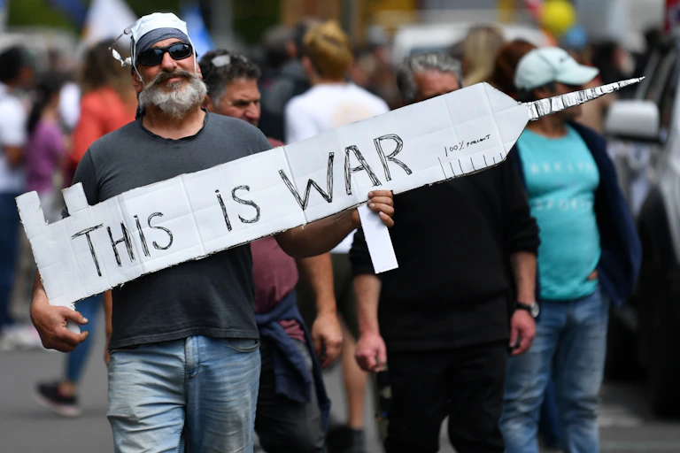 Man holding anti-vaccine protest sign.