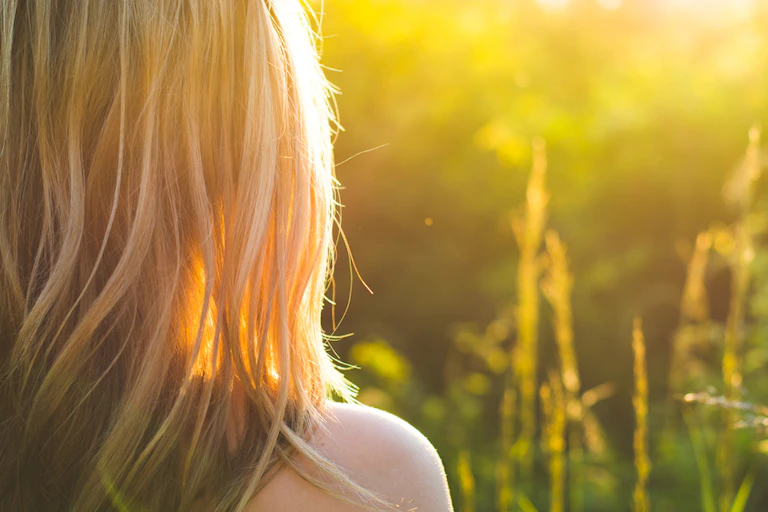 Person outside, facing the sunlight