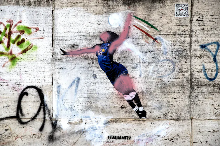 A graffiti mural of Paola Egonu playing volleyball with pink spray paint daubed over her black skin in an act of vandalism.