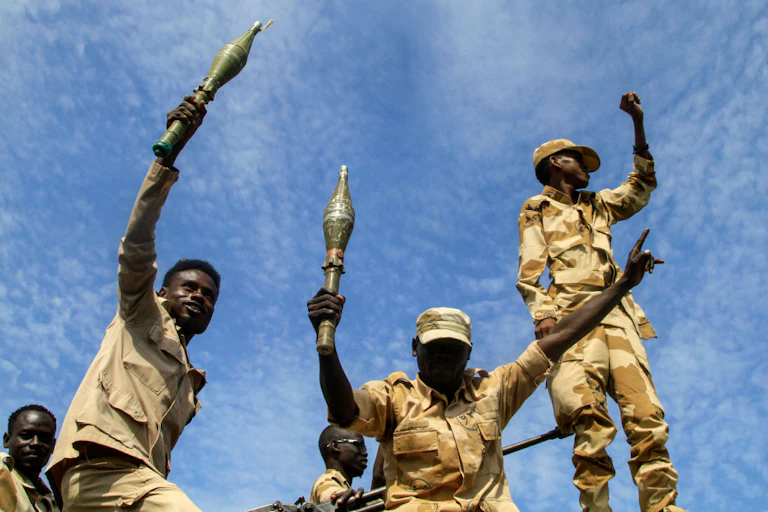Two men holding hand grenades while another holds up a clenched fist