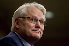 A grey-haired man with glasses.