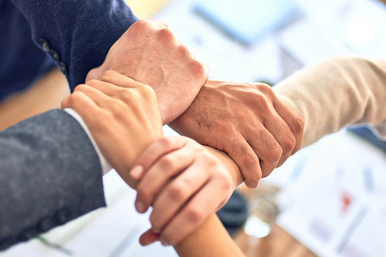 Four interlocking hands holding each other