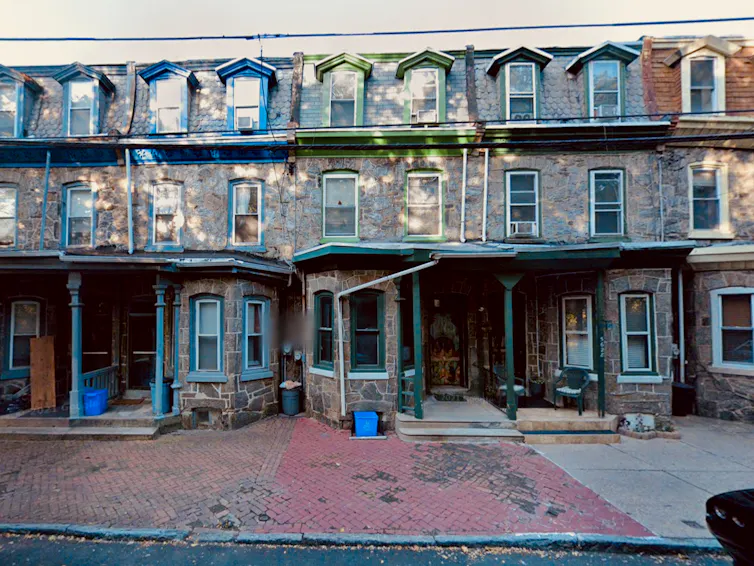 Row of three-story stone-clad rowhouses