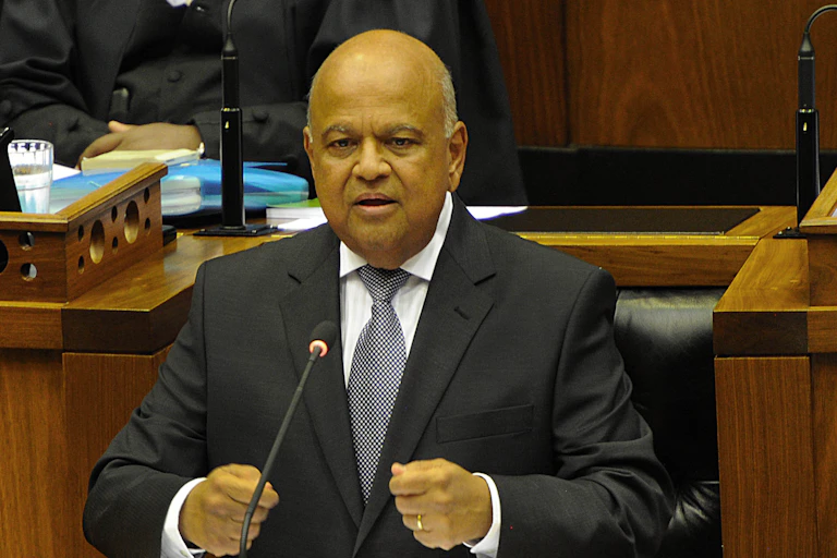 A man wearing a suit speaks at a podium.