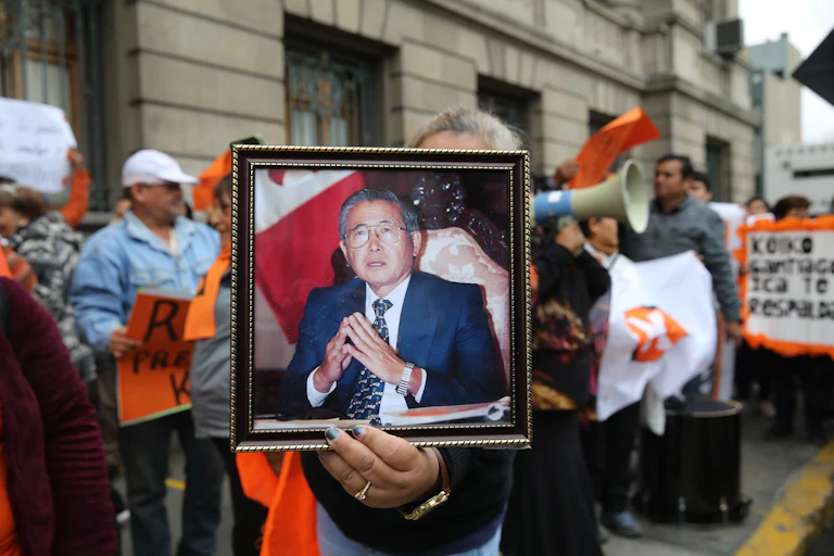 Mujer sostiene una foto de Alberto Fujimori