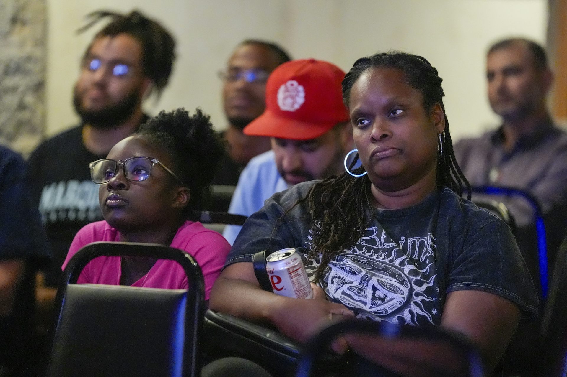People look unimpressed as they look at a screen off camera.