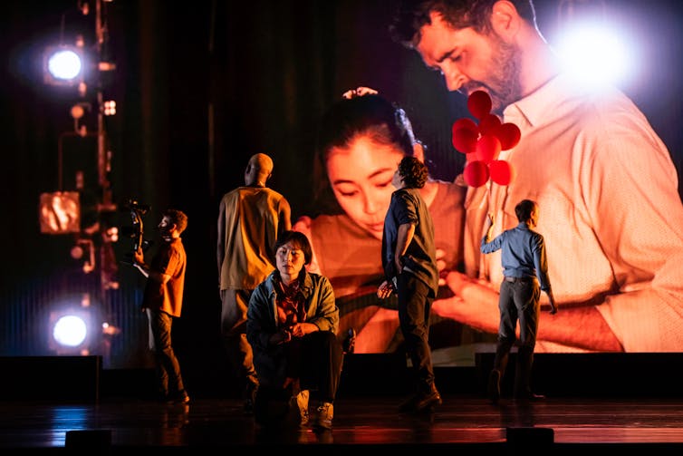 People on stage, and projected behind.