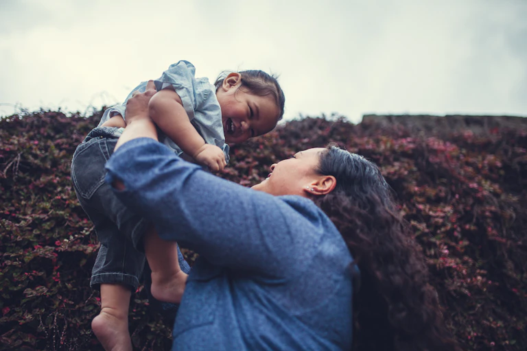 Woman holds up a young child