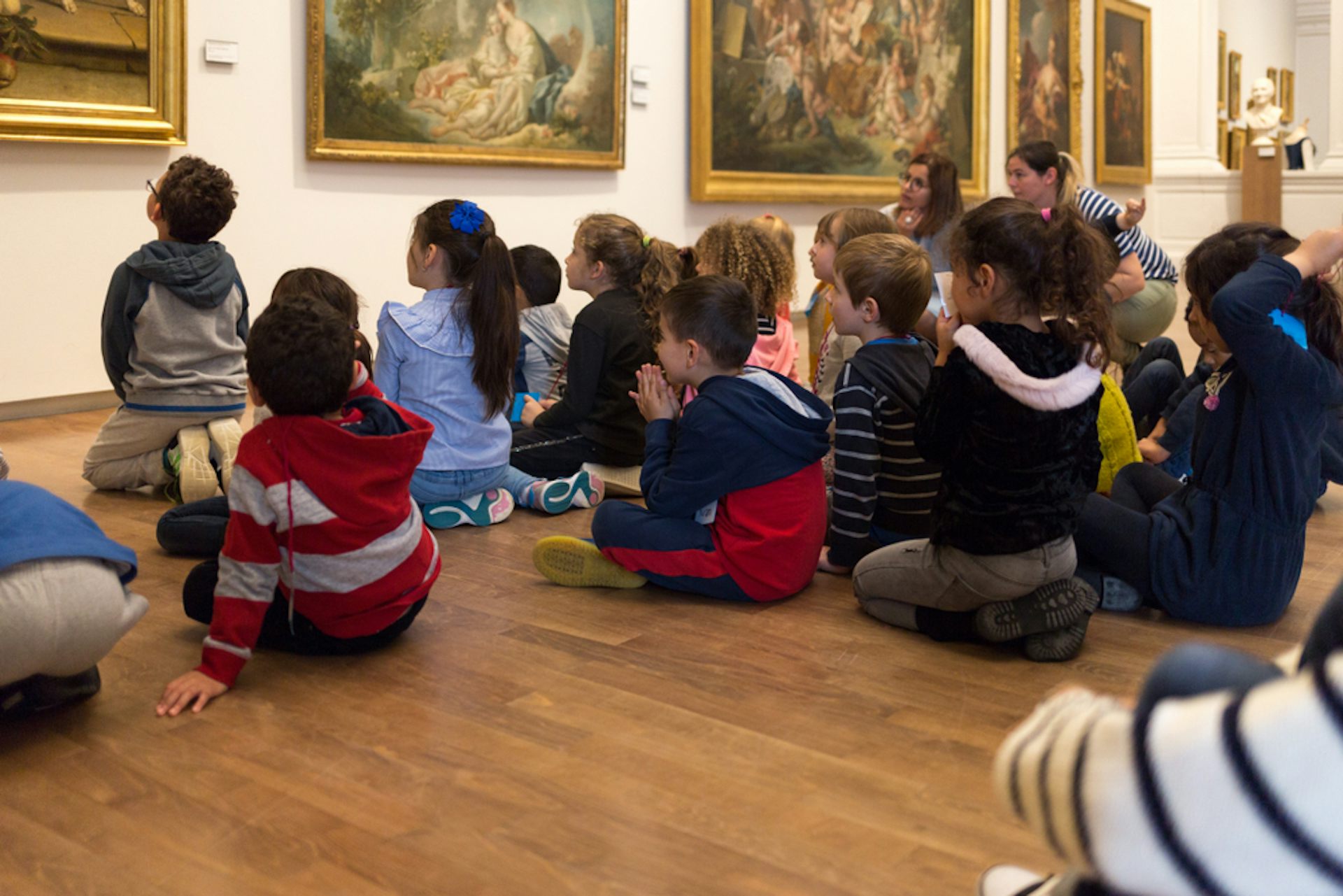 Des enfants face à des tableaux dans un musée