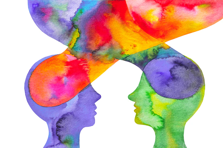 watercolor silhouettes of two heads facing each other with colorful clouds emerging and converging above