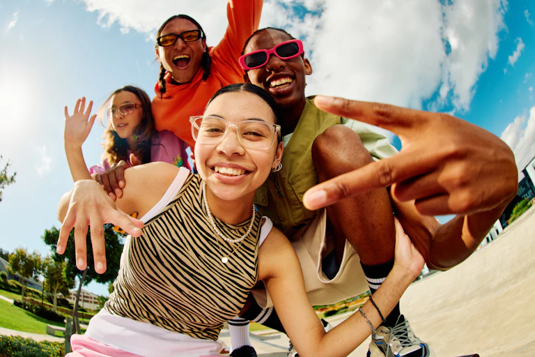 four girls cheerfully clowning around in fish-eye photo.