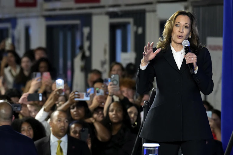 A woman stands in front of a crowd.