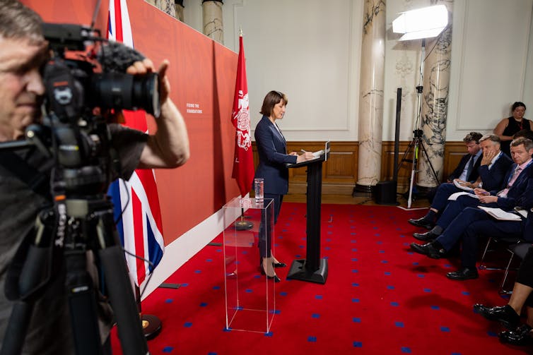 Rachel Reeves standing at a lecturn making an announcement.