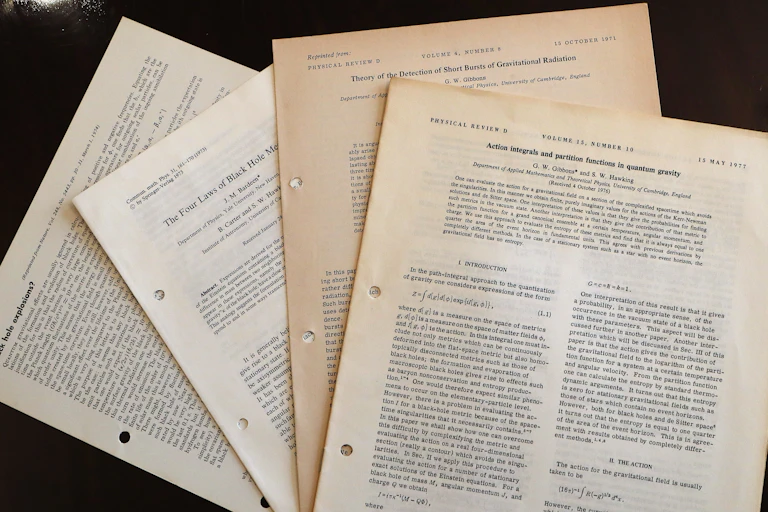 A stack of yellowing research papers.