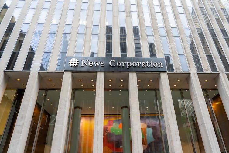 The exterior of a high rise building with a sign for News Corporation