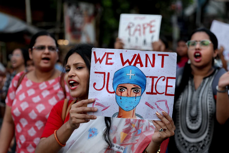 Indian women protesting with a sign featuring a doctor that says 'we want justice'.