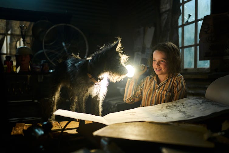 A dog, a girl with a flashlight, and inventor plans.