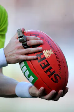 Closeup AFL umpire holding football