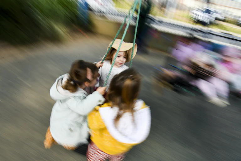 Young children play on a swing.