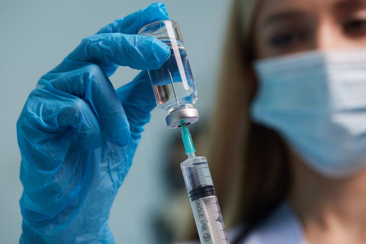 Nurse draws up vaccine vial