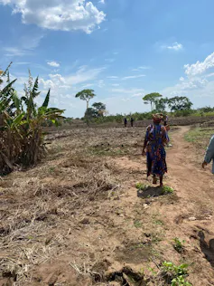 A woman walking along dusty ground