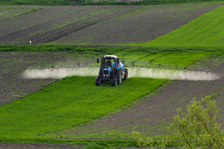 Aerial view of a tractor spraying a field.